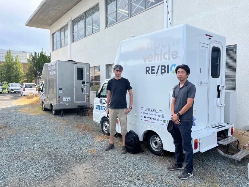 RE/BIOの車両前に立つ人々